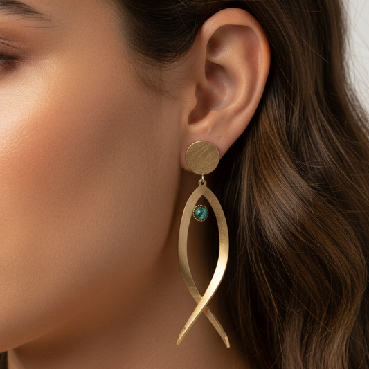 pendientes huecos ligeros con forma de pez y el ojo es de piedra natural africana verde. Son de acero hipoalergénico y resistente al agua. Son dorados y perfectos para looks casual de diario y para llevar en la piscina o en el mar.