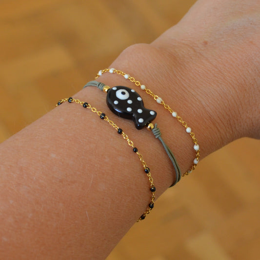 pulsera de verano de goma elástica con pez de cerámica negro con puntos blancos.