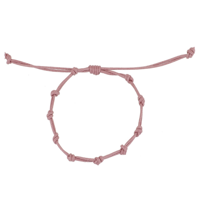 Pulsera para verano con nudos de color rosa claro . Está confeccionada en cordón encerado con dos nudos. Se puede personalizar con un colgante de letra o charms de estrella, concha o luna. El cierre es ajustable.