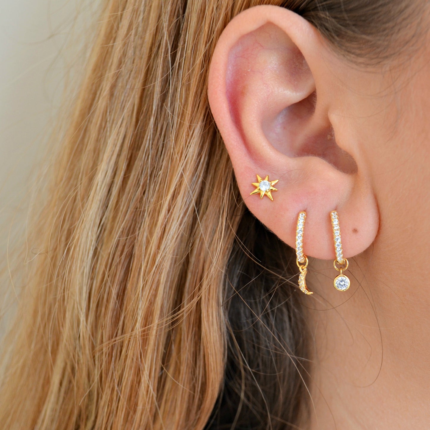 mini aros de circonitas para piercing con charms o colgantes intercambiables de estrella, luna, corazón y círculo. Están confeccionados en plata de ley con baño de oro 18 kilates.