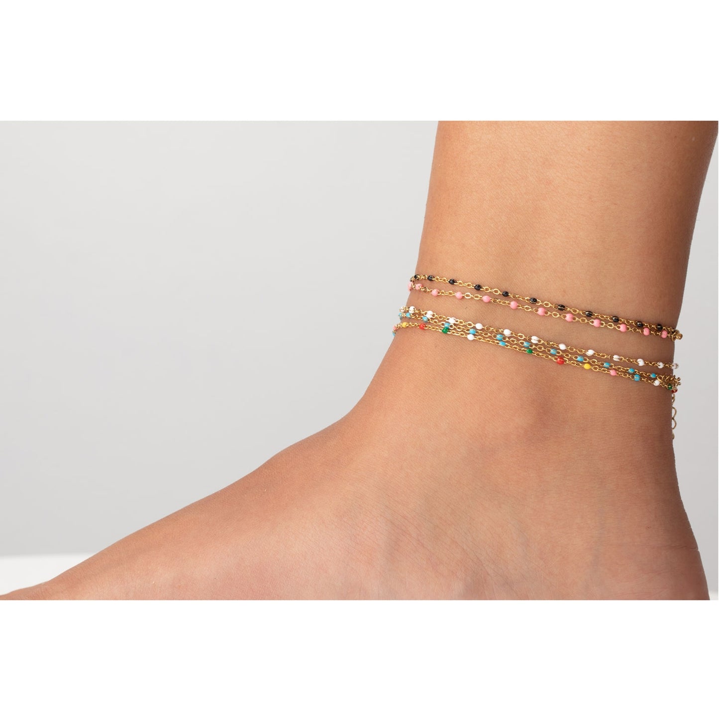 tobillera waterproof o resistente al agua confeccionada en acero con baño de oro de 3 micras. Tiene bolitas de enamel color blanco y el cierre es ajustable. golden stainless steel white bead anklet chain