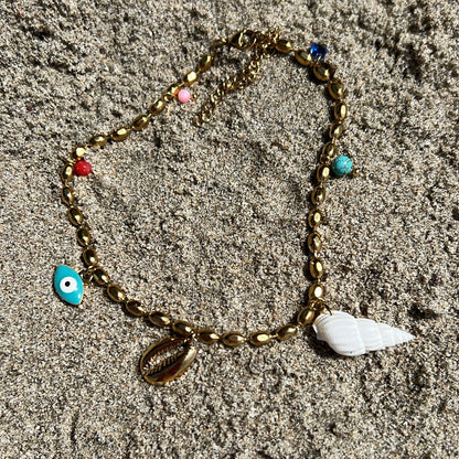 tobillera griega para verano resistente al agua en colores dorado,  azul turquesa y coral. tiene abalorios de concha y ojo turco. Es de acero hipoalergénico