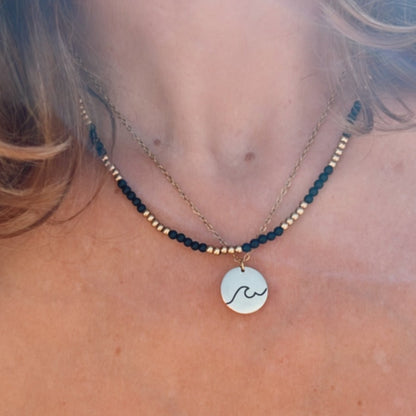 gargantilla de acero hipoalergenico y resistente al agua para bañarse en la piscina o en el mar. Tienes franjas de color negro y dorado. Perfecta para verano, otoño, invierno y primavera