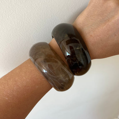 pulsera de resina en color caqui o marrón casi beige. Es ancha apra llevar por encima de mangas de jersey o camisa. 