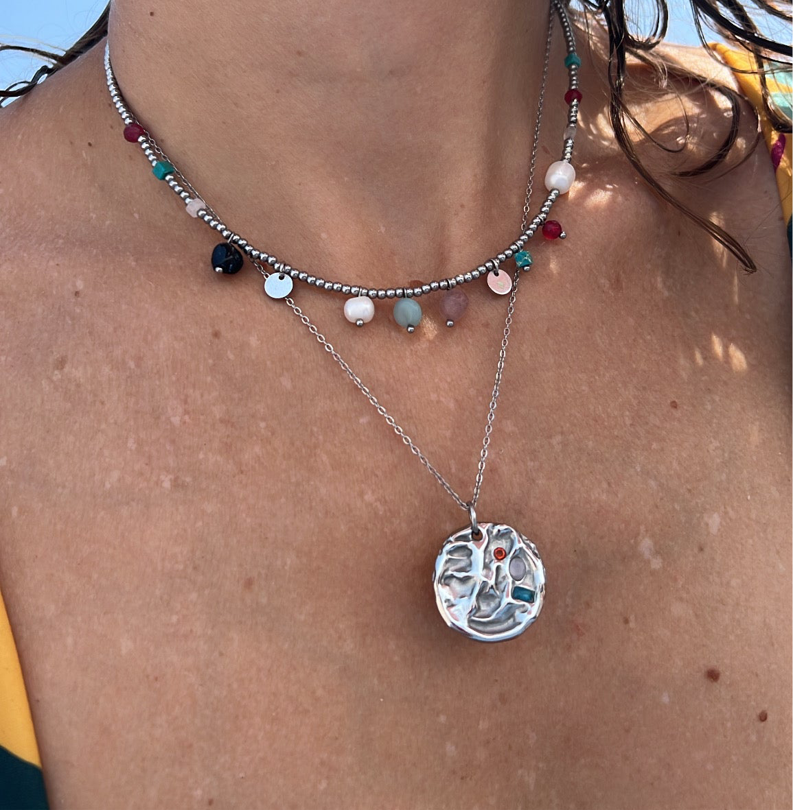 Gargantilla con medalla martillada y piedras de colores. Es de acero hipoalergénico dorado o plateado resistente al agua