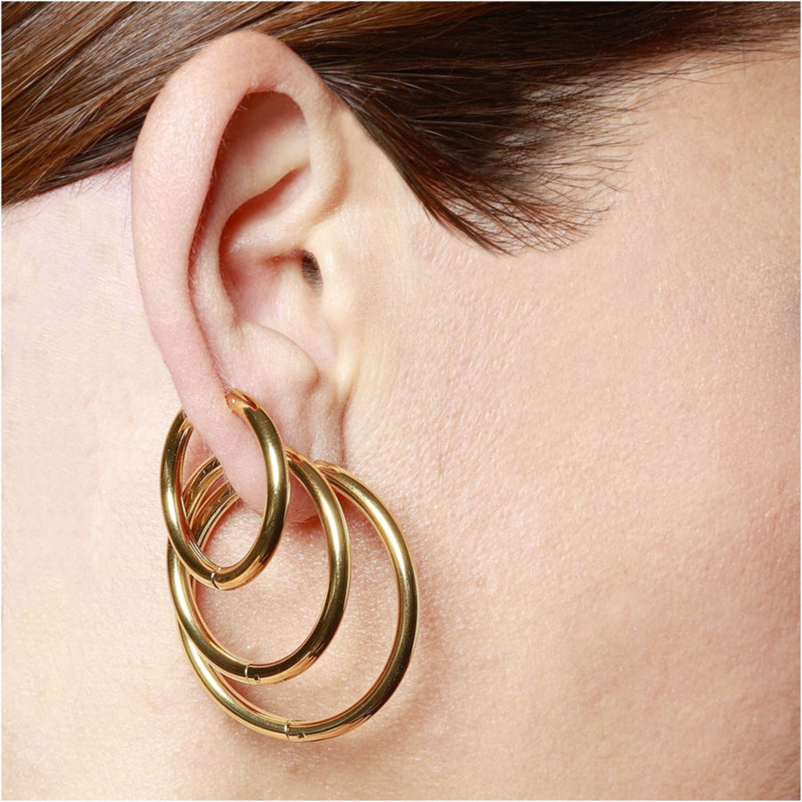 Aros básicos grandes de piercing con cierre fácil resistentes al agua. Son hipoalergénicos y están confeccionados en acero inoxidable con baño de oro 18 kilates. Gold plated stainless steel waterproof hoop earrings for piercing.