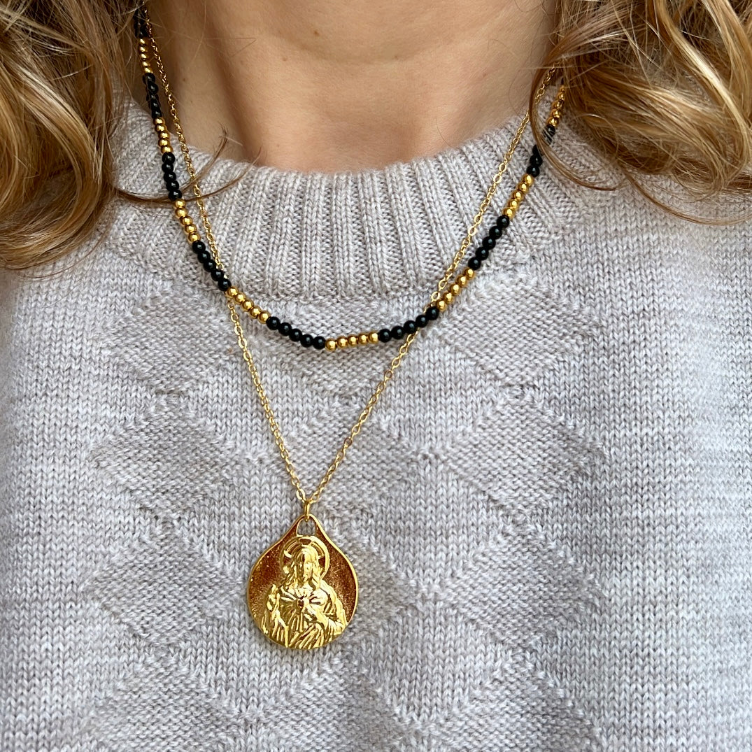 colgante con escapulario de la virgen del carmen y el sagrado corazón de jesús.  El material es acero inoxidable, quirúrgico e hipoalergénico color oro. Es un collar religioso católico perfecto para regalar en una primera comunión a niños y niñas. 