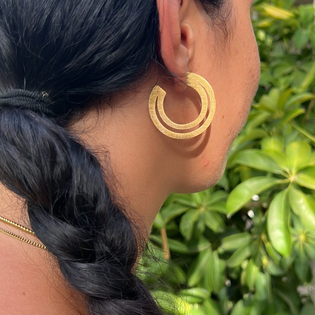 pendientes criolla grandes y ligeros de aro con textura. Son de acero hipoalergénico y resistente al agua. Acabado dorado con forma de media luna.
