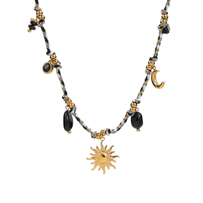collar boho chic de cordón negro, dorado y blanco con piedra natural onix y abalorios dorados como sol y luna. 