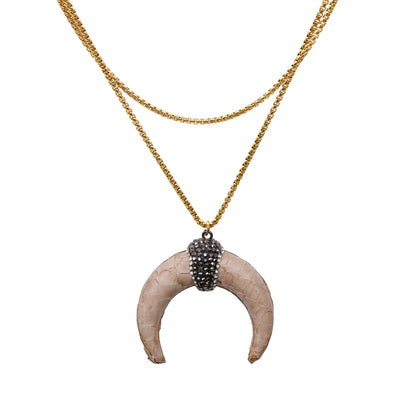 collar largo con colgante de cuerno media luna en piel color marfil. la cadena es de acero hipoalergénico y resistente al agua