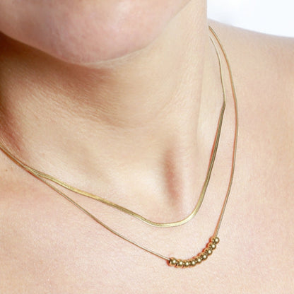 Collar boho de dos cadenas juntas, una de bolitas y otra de escama herringbone. Es de acero hipoalergénicos resistente al agua. Son 2 collares en 1.