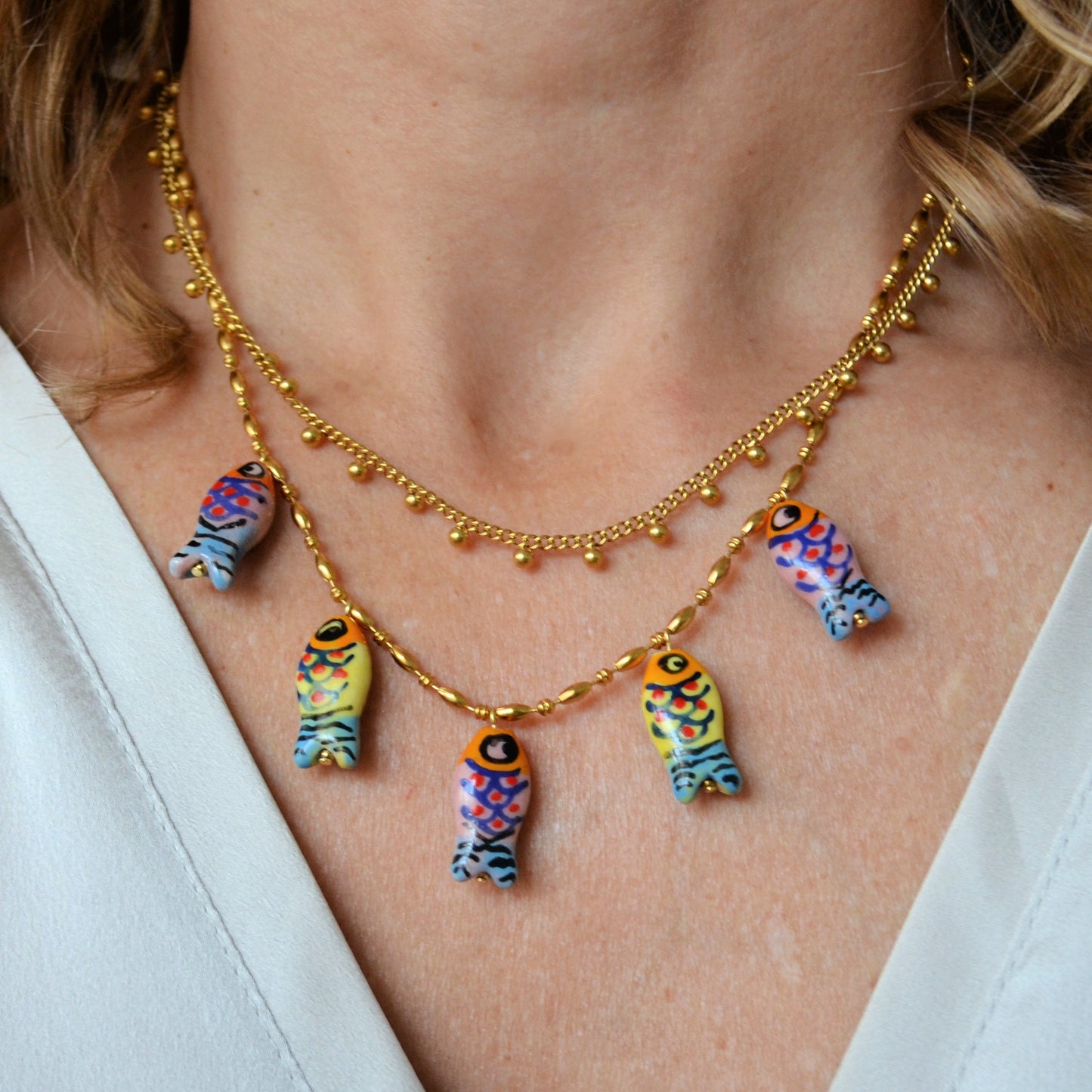 COLLAR waterproof o resistente al agua confeccionada en acero con baño de oro 18 kilates. Los abalorios con peces colores DE cerámica (CORAL, azul TURQUESA, naranja rojo Y VERDE)