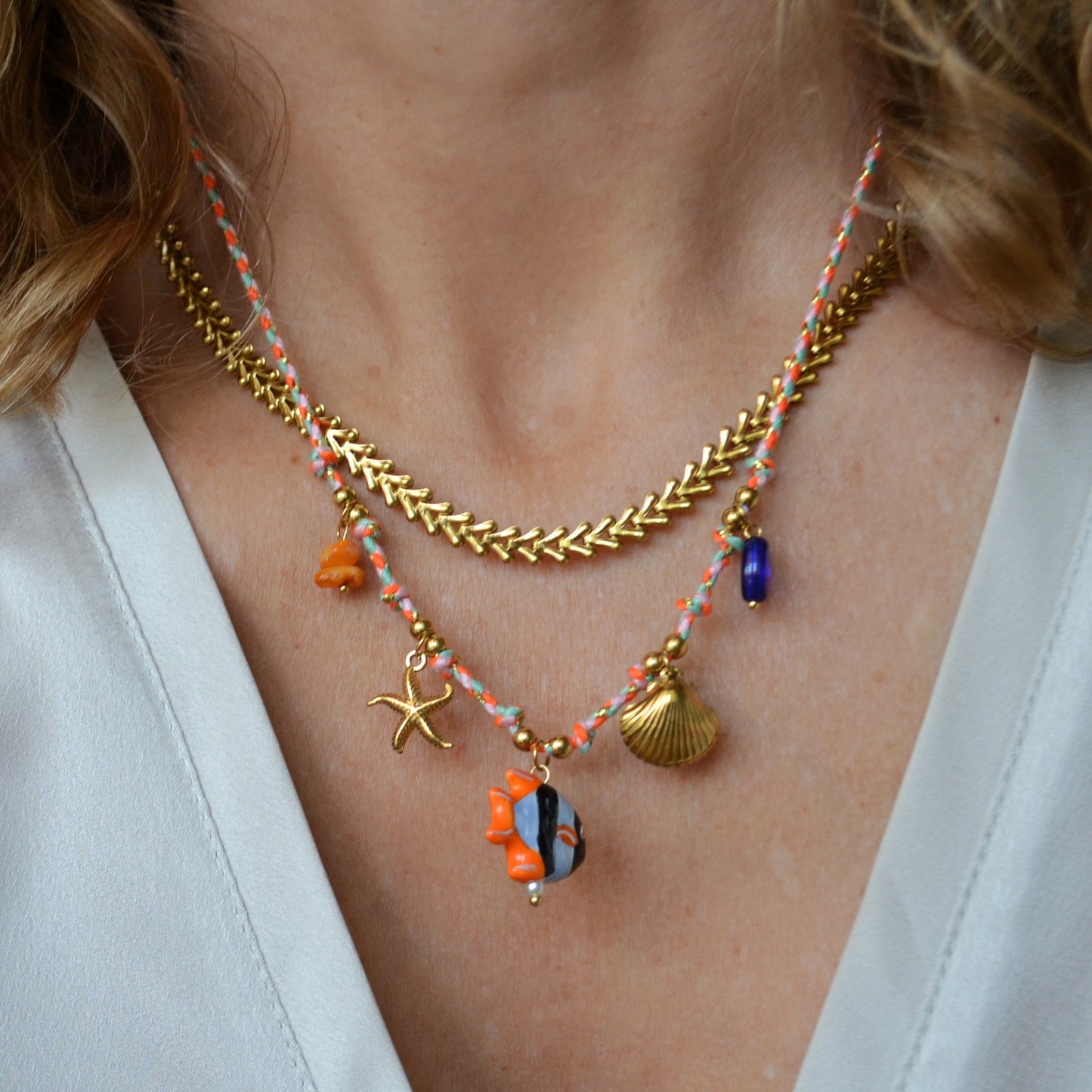 COLLAR para verano de CORDÓN naranja con acero hipoalergénico y waterproof dorado. Los abalorios son concha, estrella de mar y pez en naranja y azul. 
