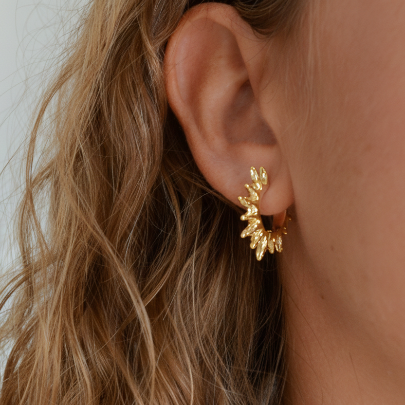 Pendientes de aro en forma de rayos de sol en dorado o plateado. Son de acero hipoalergenico, resistente al agua y no pesan. Perfectos para looks de noche y de día, para fiestas y trabajar
