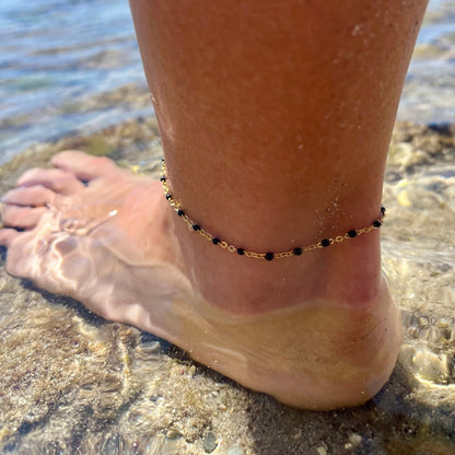 tobillera waterproof o resistente al agua confeccionada en acero con baño de oro de 3 micras. Tiene bolitas de enamel color negro y el cierre es ajustable. golden stainless steel black bead anklet chain