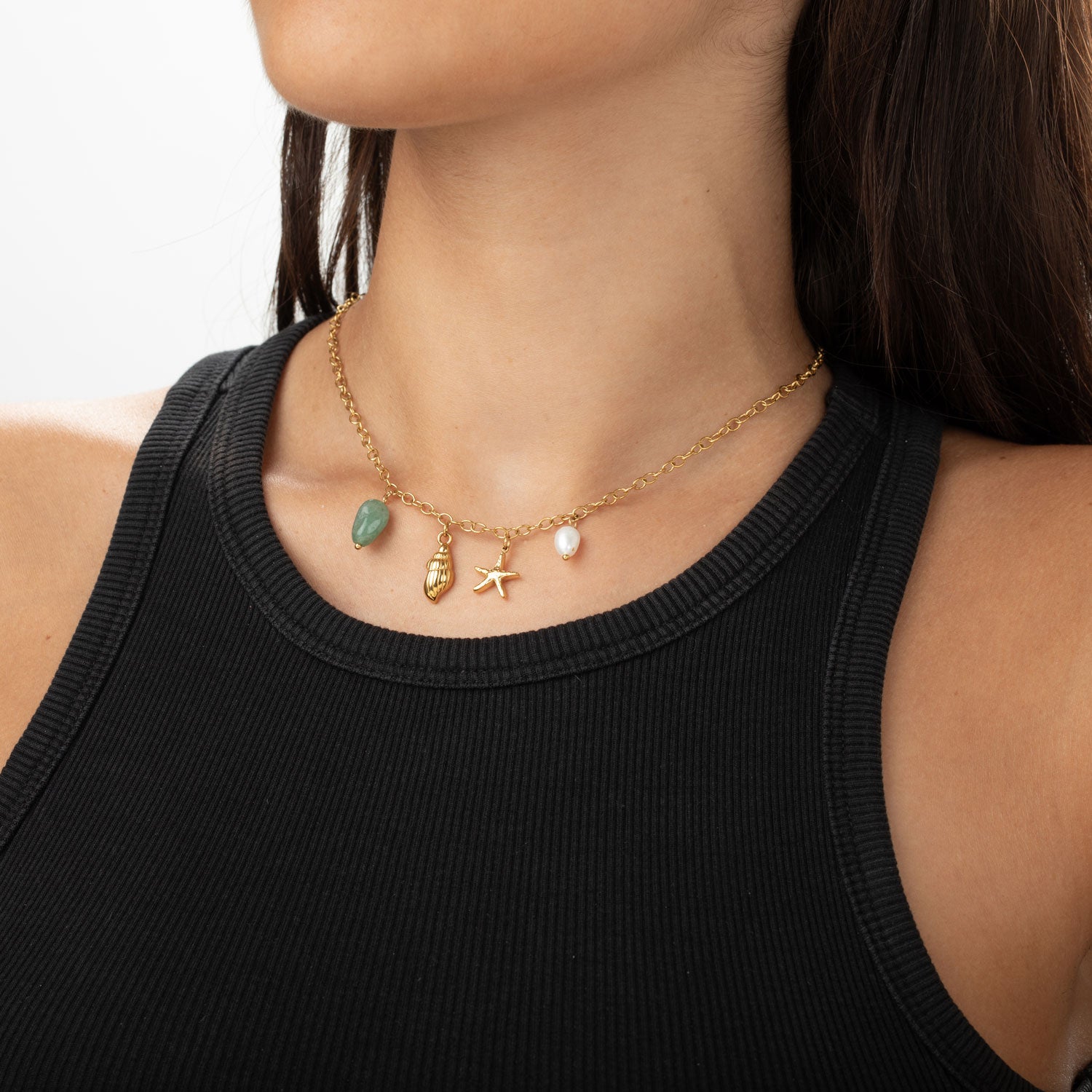 COLLAR waterproof o resistente al agua confeccionadao en acero con baño de oro 18 kilates. Tiene abalorios de colores imitando piedra natural turquesa y perla cultivada. también tiene colgantes de estrella de mar y una concha o caracola.