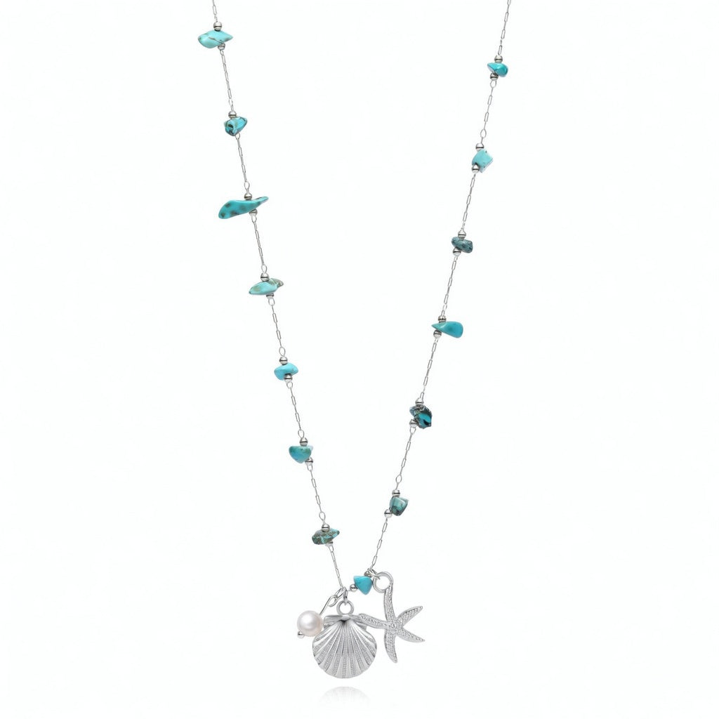 COLLAR waterproof o resistente al agua confeccionada en acero con baño de oro 18 kilates. Tiene abalorios de colores imitando piedra natural turqyesa y perla cultivada. también tiene colgantes de estrella de mar y concha. 