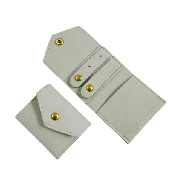 joyero enrollable pequeño de viaje con cierre automático para llevar collares, pulseras, anillos y pendientes. Tiene revestimiento de microfibra para proteger las joyas y que no se rayen. es un regalo perfecto para el día de la madre, para niñas y adolescentes. 