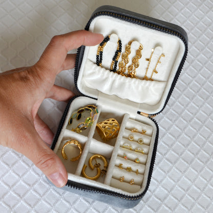 joyero cuadrado pequeño de viaje con cierre de cremallera y compartimentos para llevar collares, pulseras, anillos y pendientes. Tiene revestimiento de terciopelo o microfibra para proteger las joyas y que no se rayen. es un regalo perfecto para el día de la madre, para niñas y adolescentes. 