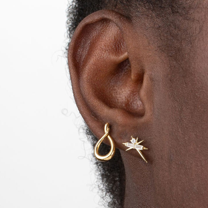 pendiente para piercing con pinchos y rayos. es de plata de ley con baño de oro 18 kilates. 