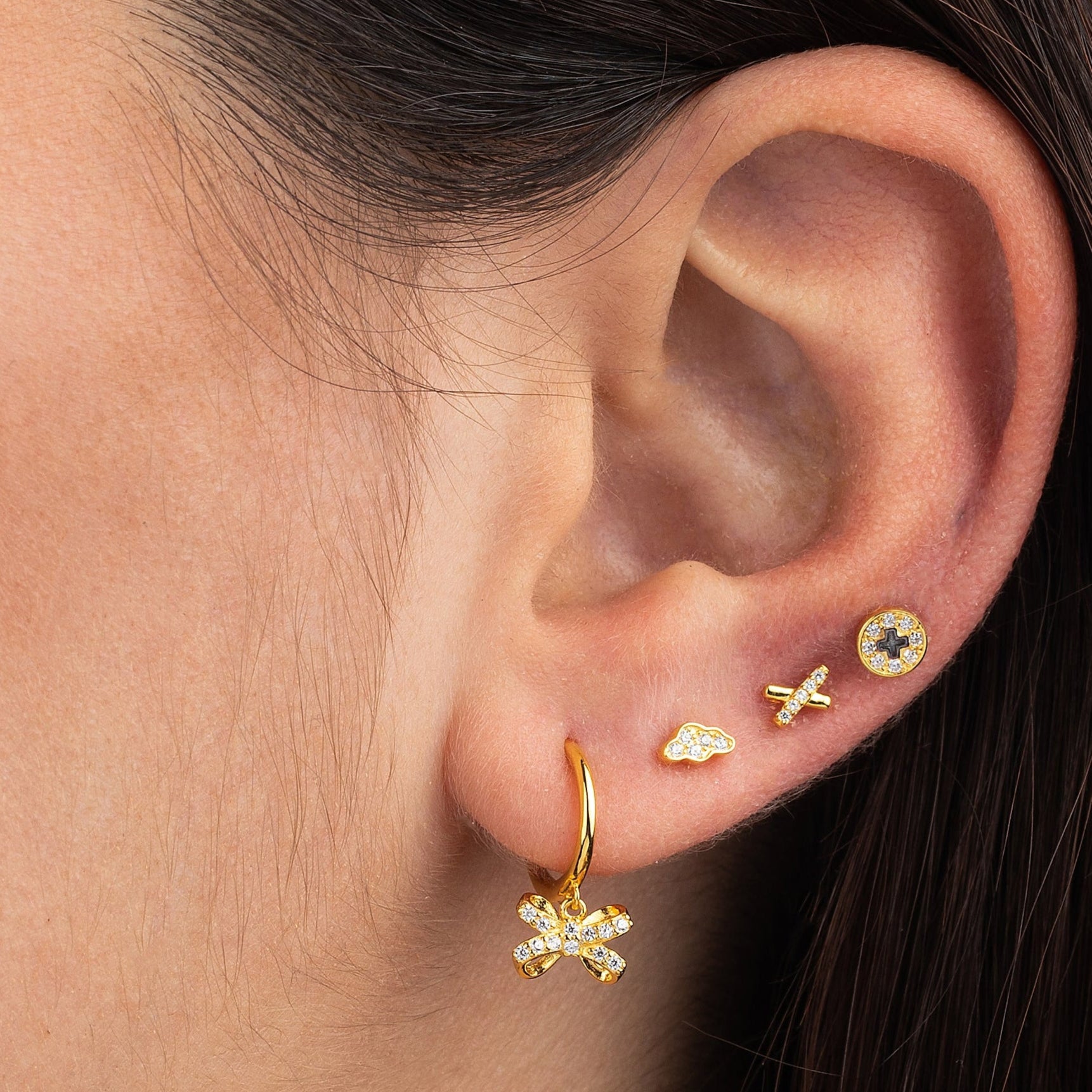 pendiente  de piercing cruzado en forma de x. Es de plata de ley con baño de oro 18 kilates y circonitas. Hipoalergénico