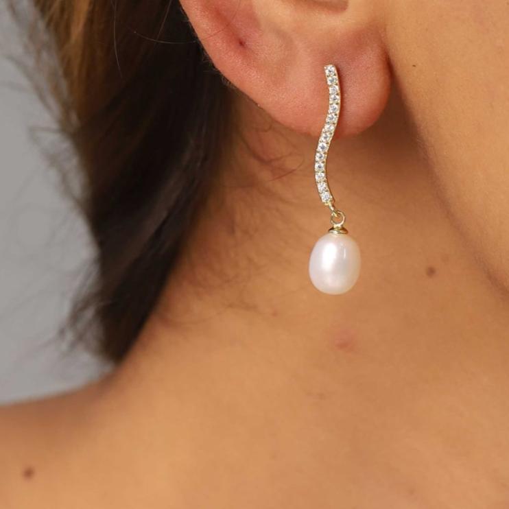 pendientes de fiesta largos con brillantes tipo tenis con perla. es de plata de ley con baño de oro 18 kilates. gold plated sterling silver long zircon and pearl tennis chain holiday earrings