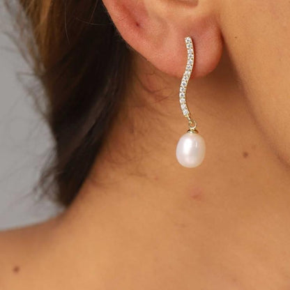 pendientes de fiesta largos con brillantes tipo tenis con perla. es de plata de ley con baño de oro 18 kilates. gold plated sterling silver long zircon and pearl tennis chain holiday earrings