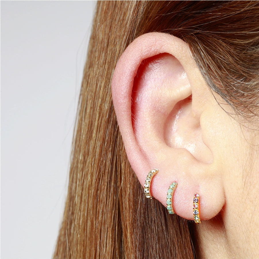 pendiente de piercing con aro flexible y brillante que es fácil de poner. es de plata de ley con baño de oro 18 kilates. Colores disponibles: blanco, negro, azul turquesa y multicolor. Gold hoop huggie piercing earring