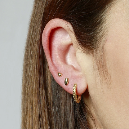 pendientes de piercing hipoalergénicos para cartílago o helix. Son de plata de ley con baño de oro 18 kilates. Tienen forma de óvalo o gota y cierre plano por detrás.