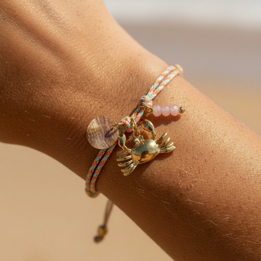 pulsera waterproof o resistente al agua confeccionada con cordón dorado y rosa con abalorios de piedra natural y acero dorado.  Cierre ajustable, colgante de concha, pez, cangrejo y abalorios de colores (CORAL, azul TURQUESA, naranja)