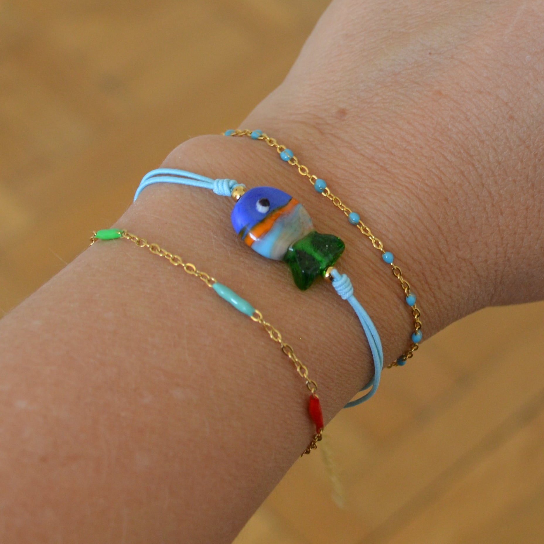 pulsera de verano de goma elástica con pez de cerámica a rayas de colores azul verde y naranja