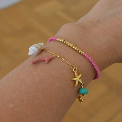 pulsera waterproof o resistente al agua confeccionada EN CADENA DE Oeslabones grande de acero con baño de oro 18 kilates.  Cierre frontal con colgante de concha, caracola, palmera  y abalorios de colores (CORAL, azul TURQUESA, naranja rojo Y VERDE)