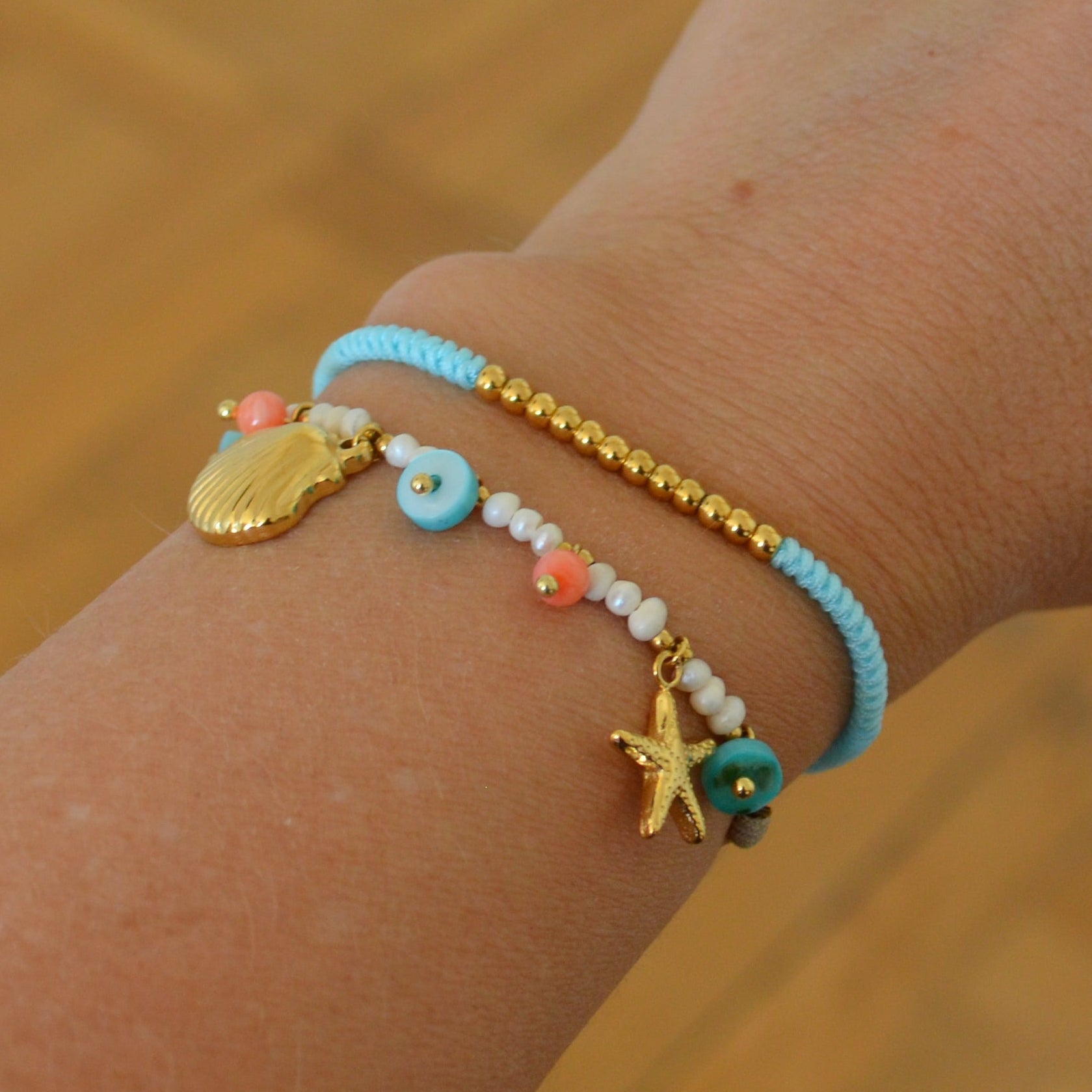 pulsera waterproof o resistente al agua confeccionada con cordón marrón y abalorios de perla, acero con baño de oro 18 kilates.  Cierre ajustable, colgante de concha, caracola, estrella de mar y abalorios de colores (CORAL, azul TURQUESA, naranja)