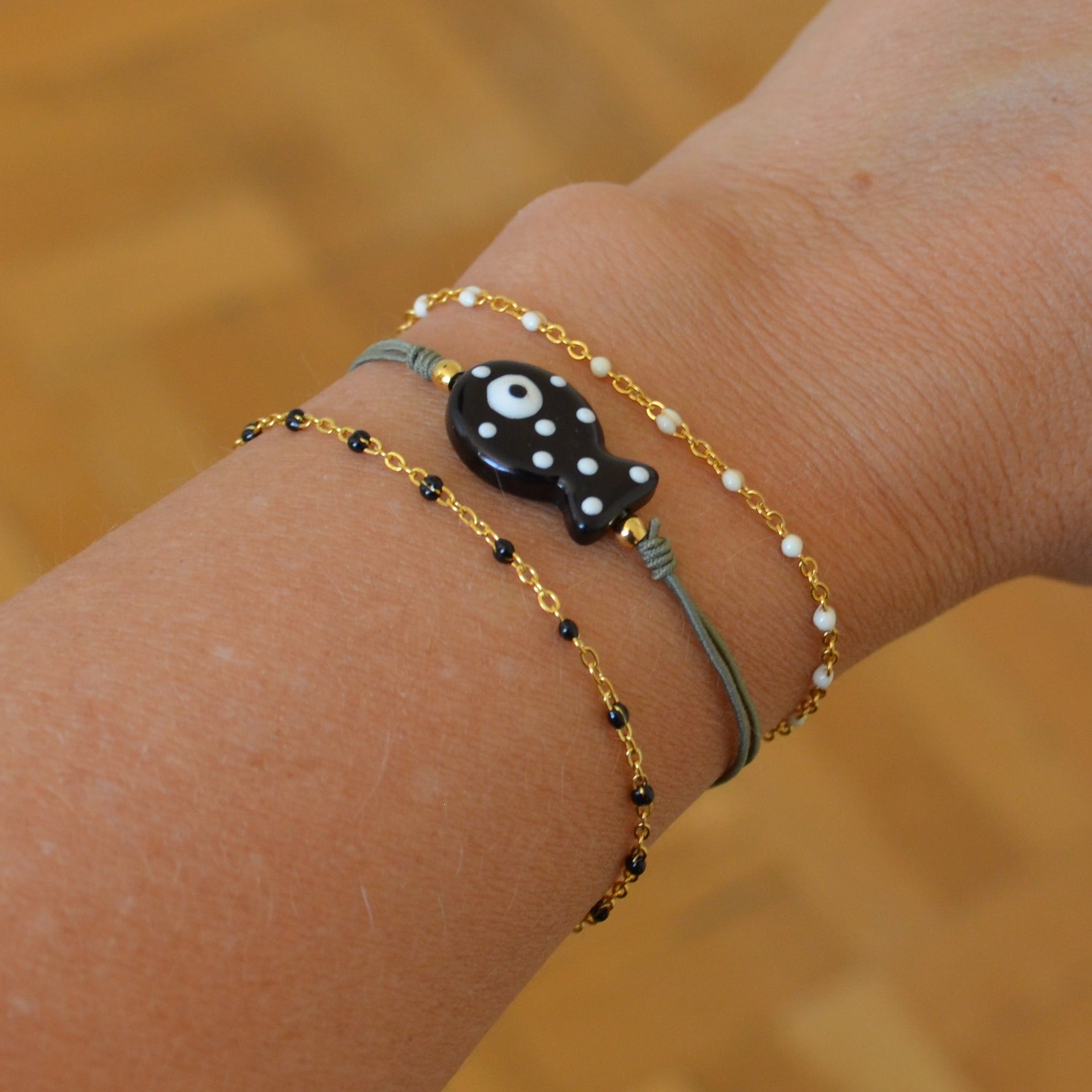 pulsera de verano de goma elástica con pez de cerámica negro con puntos blancos. 