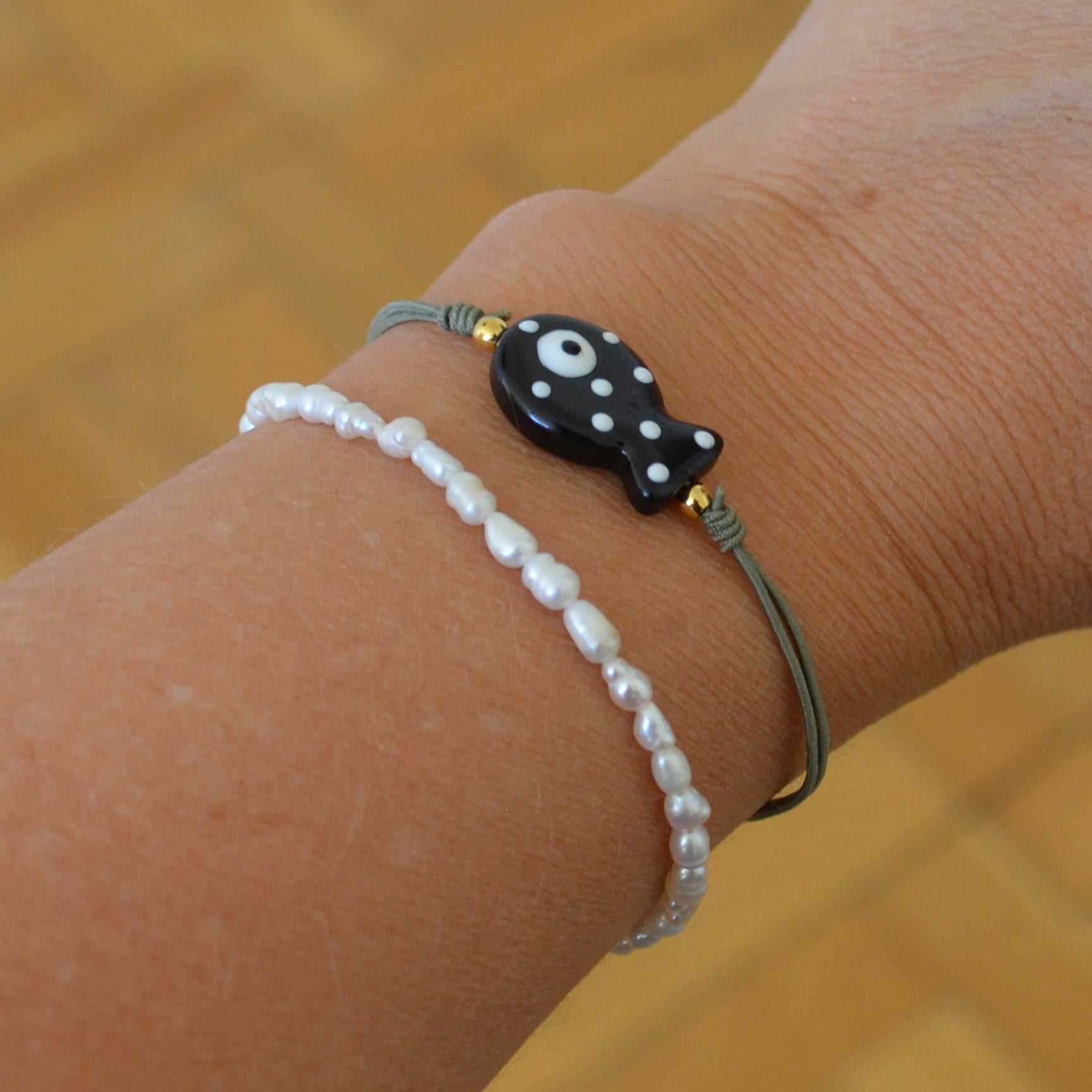 pulsera de verano de goma elástica con pez de cerámica negro con puntos blancos. 