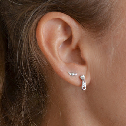 pendientes pequeños para piercing de plata de ley con baño de oro 18 kilates. Tienen forma de nudo, guindilla, cremallera, equis, corazón con alas y mano rockera