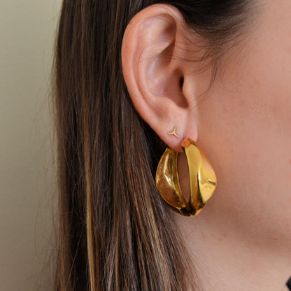pendientes de aro grande con forma de onda en acero hipoalergénico y resistente al agua. disponibles en dorado y plateado. gold plated stainless steel wavy hoop earrings
