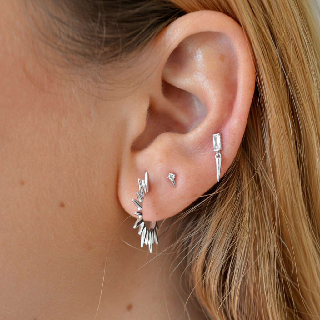 mini pendientes de piercing con circonita y pincho o cono que están confeccionados en plata de ley con baño de oro 18 kilates