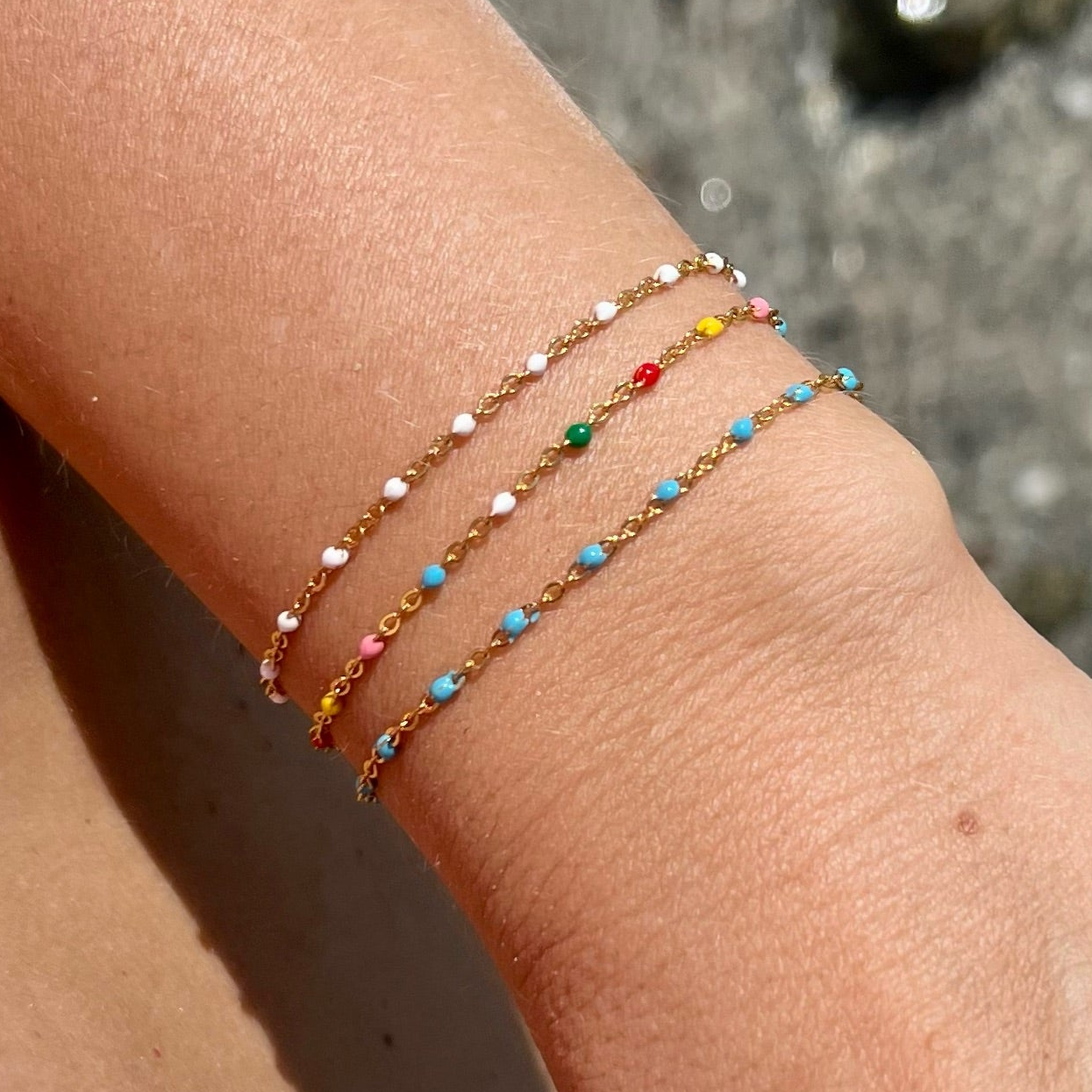 pulsera dorada waterproof o resistente al agua confeccionada en acero con baño de oro de 3 micras. Tiene bolitas de enamel blancas y el cierre es ajustable. collar hipoalergénico e inoxidable. gold plated stainless steel white bead bracelet.