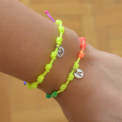 Pulsera para verano amarillo fluor con nudos de colores. Está confeccionada en cordón encerado con nudos. Se puede personalizar con un colgante de letra con las iniciales de los hijos o los nietos. El cierre es ajustable. Es un regalo perfecto para niñas o para el dia de la madre. 