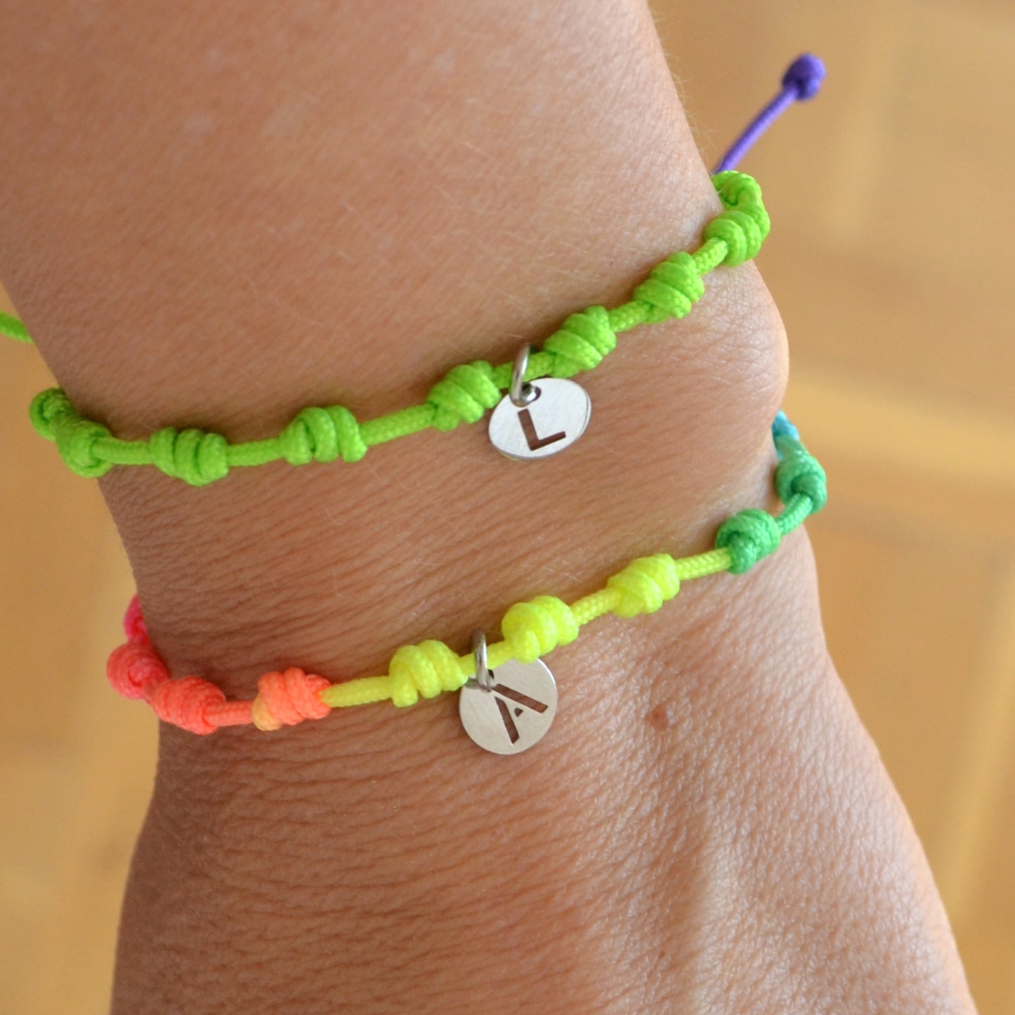 Pulsera para verano fluor con nudos de colores. Está confeccionada en cordón encerado con nudos. Se puede personalizar con un colgante de letra con las iniciales de los hijos o los nietos. El cierre es ajustable. Es un regalo perfecto para niñas o para el dia de la madre. 