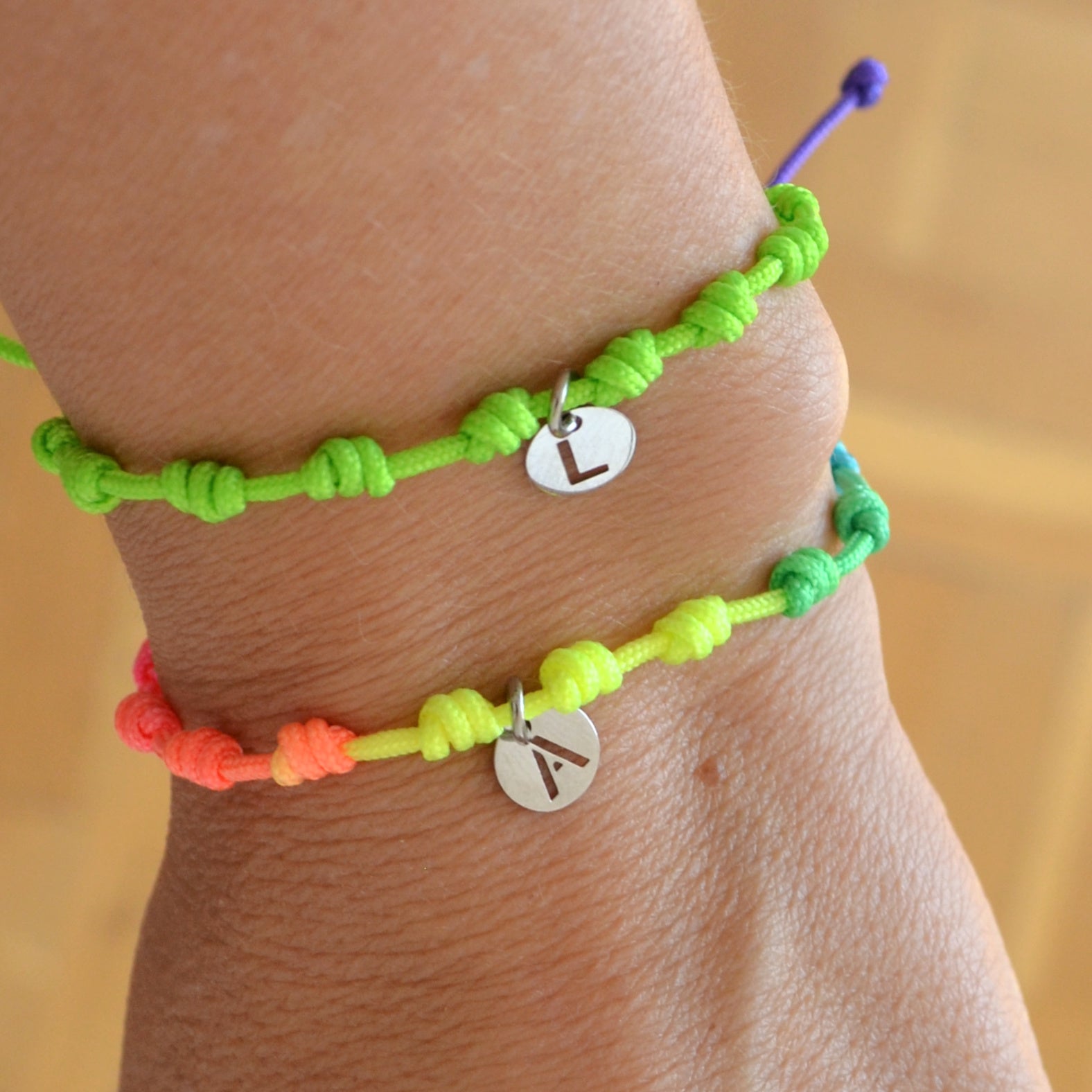 Pulsera para verano fluor con nudos de colores. Está confeccionada en cordón encerado con nudos. Se puede personalizar con un colgante de letra con las iniciales de los hijos o los nietos. El cierre es ajustable. Es un regalo perfecto para niñas o para el dia de la madre. 