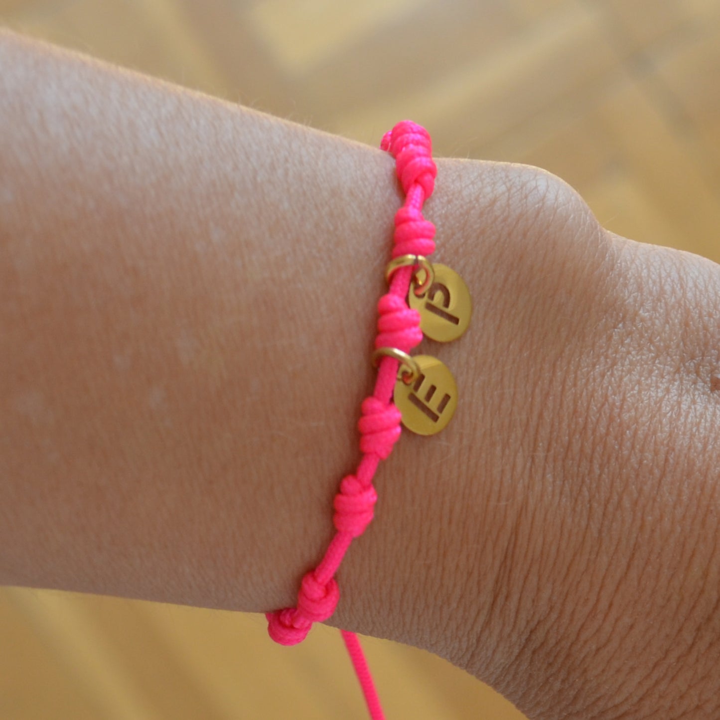 Pulsera para verano rosa fucsia con nudos de colores. Está confeccionada en cordón encerado con nudos. Se puede personalizar con un colgante de letra con las iniciales de los hijos o los nietos. El cierre es ajustable. Es un regalo perfecto para niñas o para el dia de la madre. 