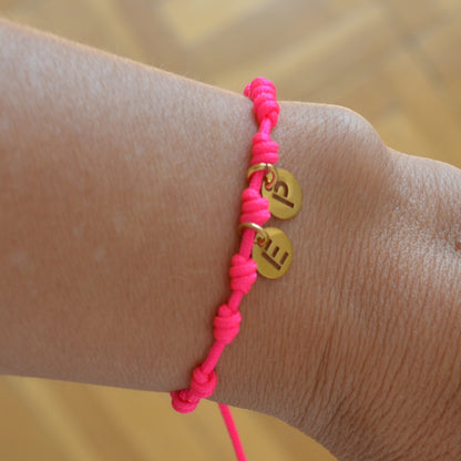 Pulsera para verano rosa fucsia con nudos de colores. Está confeccionada en cordón encerado con nudos. Se puede personalizar con un colgante de letra con las iniciales de los hijos o los nietos. El cierre es ajustable. Es un regalo perfecto para niñas o para el dia de la madre. 
