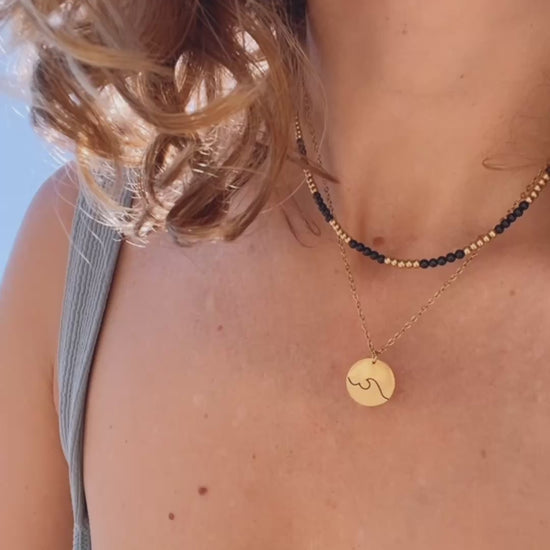 gargantilla de acero hipoalergenico y resistente al agua para bañarse en la piscina o en el mar. Tienes franjas de color negro y dorado. Perfecta para verano, otoño, invierno y primavera