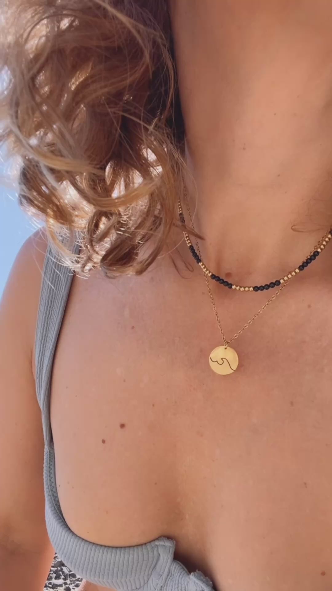 gargantilla de acero hipoalergenico y resistente al agua para bañarse en la piscina o en el mar. Tienes franjas de color negro y dorado. Perfecta para verano, otoño, invierno y primavera