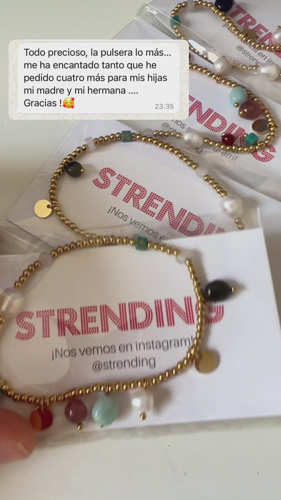 pulsera elástica waterproof o resistente al agua confeccionada en acero con baño de oro 18 kilates. Tiene abalorios de colores imitando piedra natural y perla cultivada. 