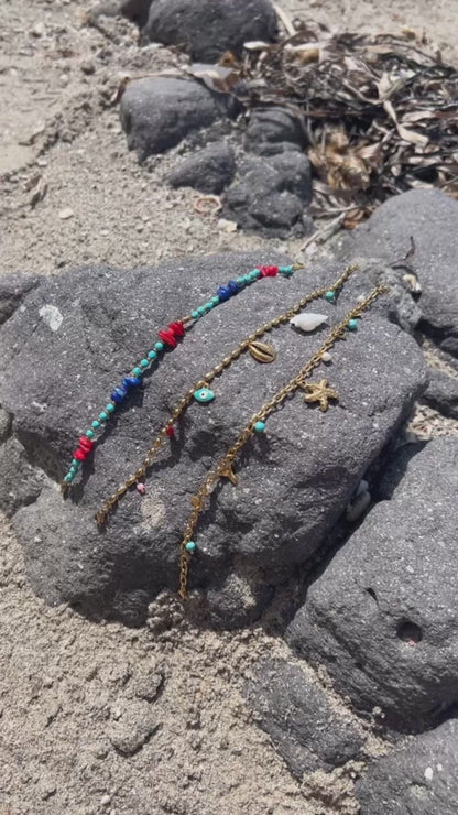 tobillera para verano resistente al agua en colores dorado,  azul turquesa y coral. tiene abalorios de concha, ESTRELLA DE MAR Y cola de ballena. Es de acero hipoalergénico