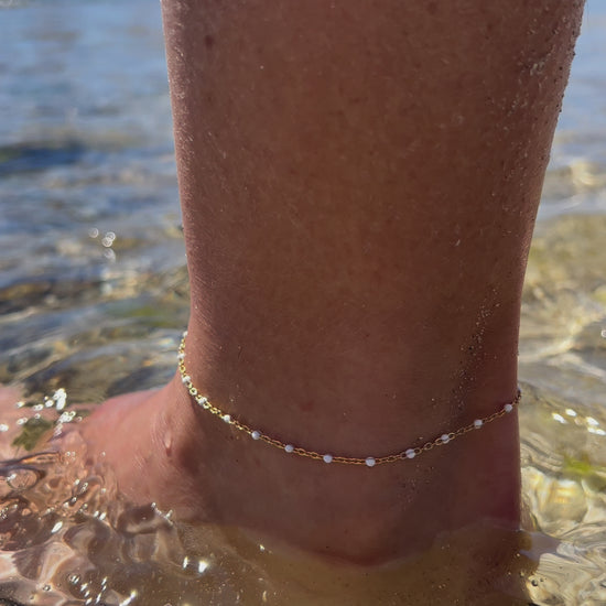 tobillera waterproof o resistente al agua confeccionada en acero con baño de oro de 3 micras. Tiene bolitas de enamel color blanco y el cierre es ajustable. golden stainless steel white bead anklet chain