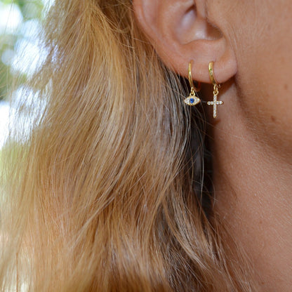 aros pequeños con colgante o charm en forma de cruz con circonitas y confeccionados en plata de ley y baño de oro 18 kilates